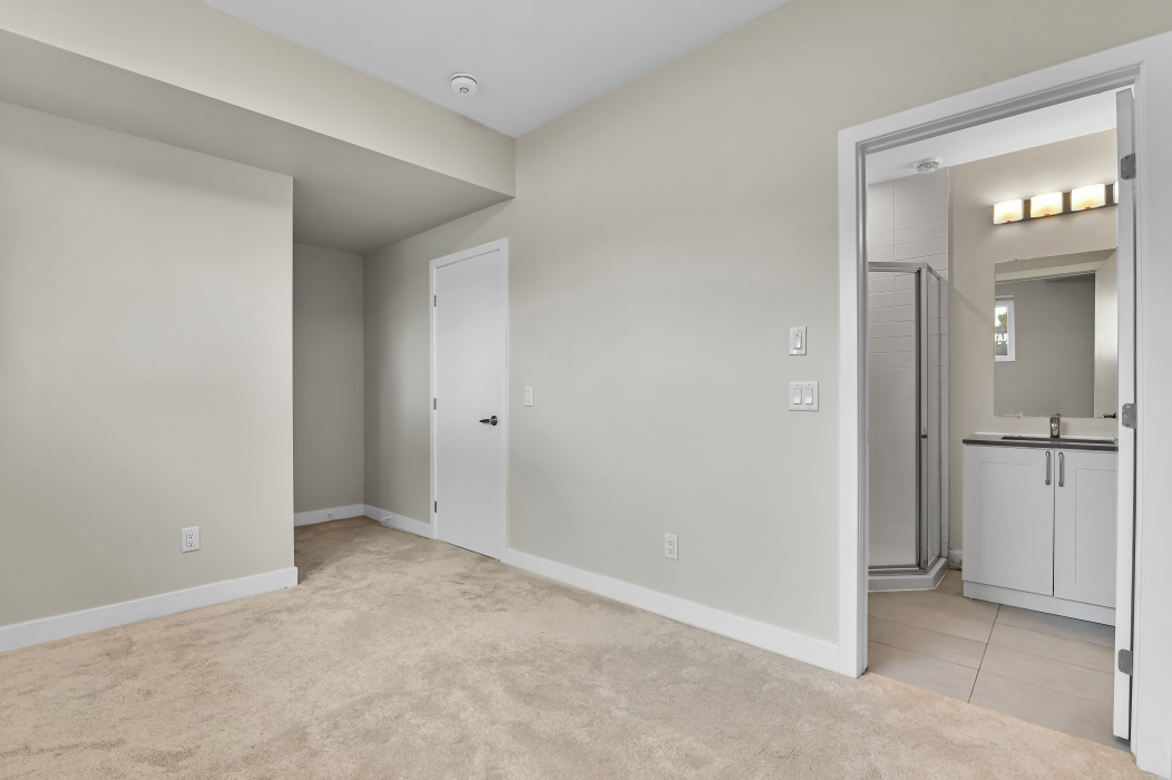 Master bedroom with an attached ensuite bathroom in a 2-bedroom townhouse.