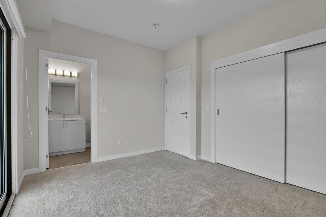 Master bedroom featuring an ensuite bathroom in the 2-bed townhouse.