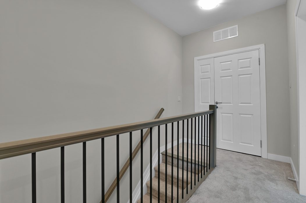 Third-level stairs and landing in the unfurnished townhouse.
